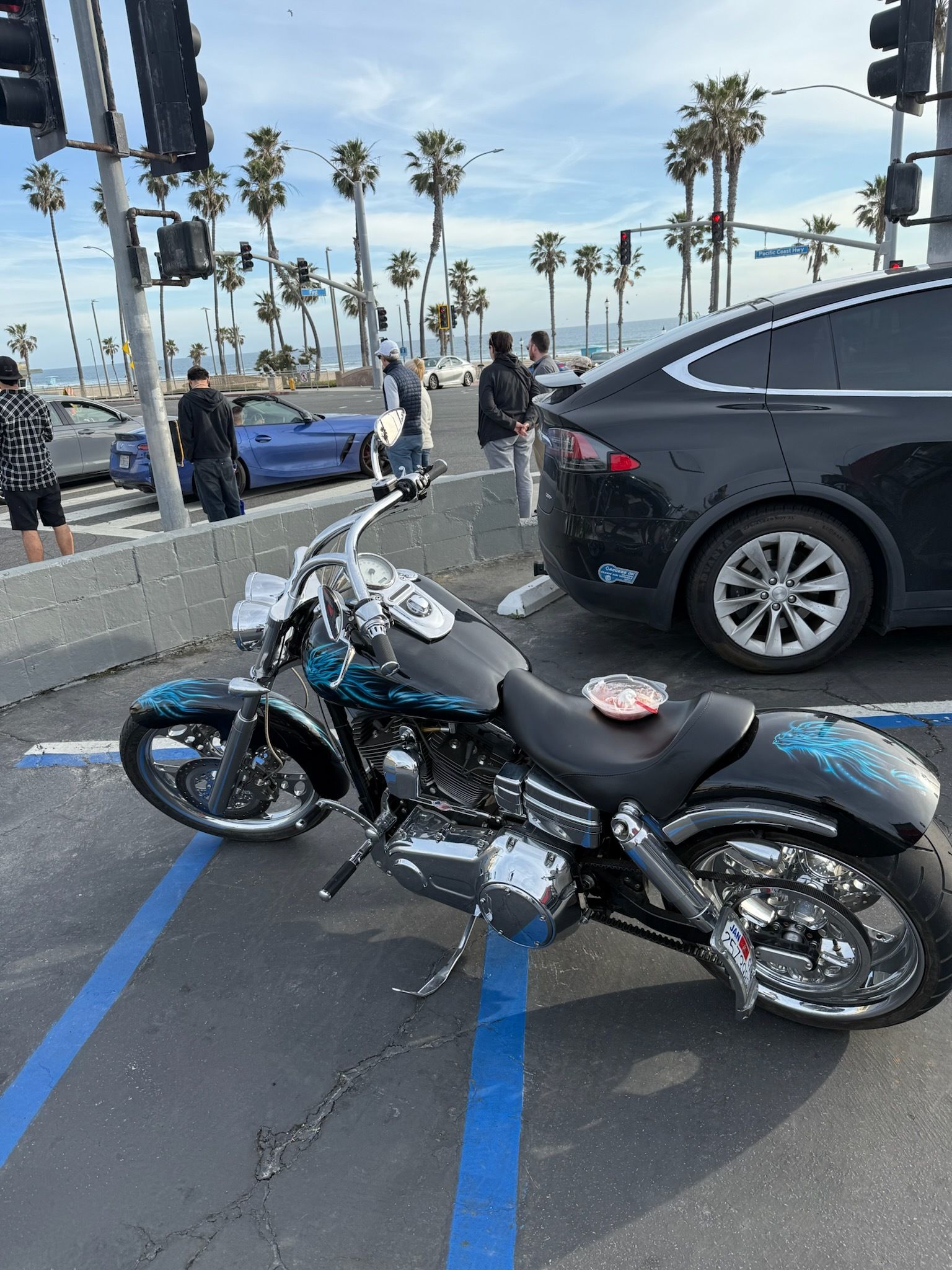 A motorcycle is parked in a parking lot next to a car.