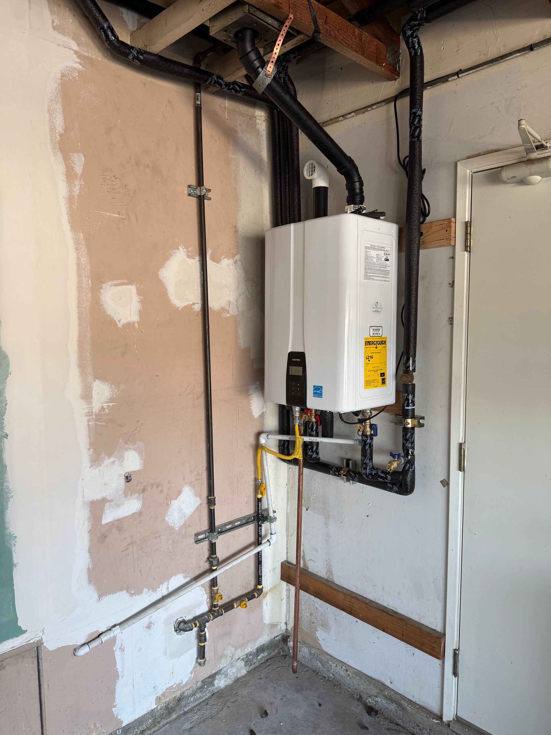 A water heater is hanging on a wall in a room.