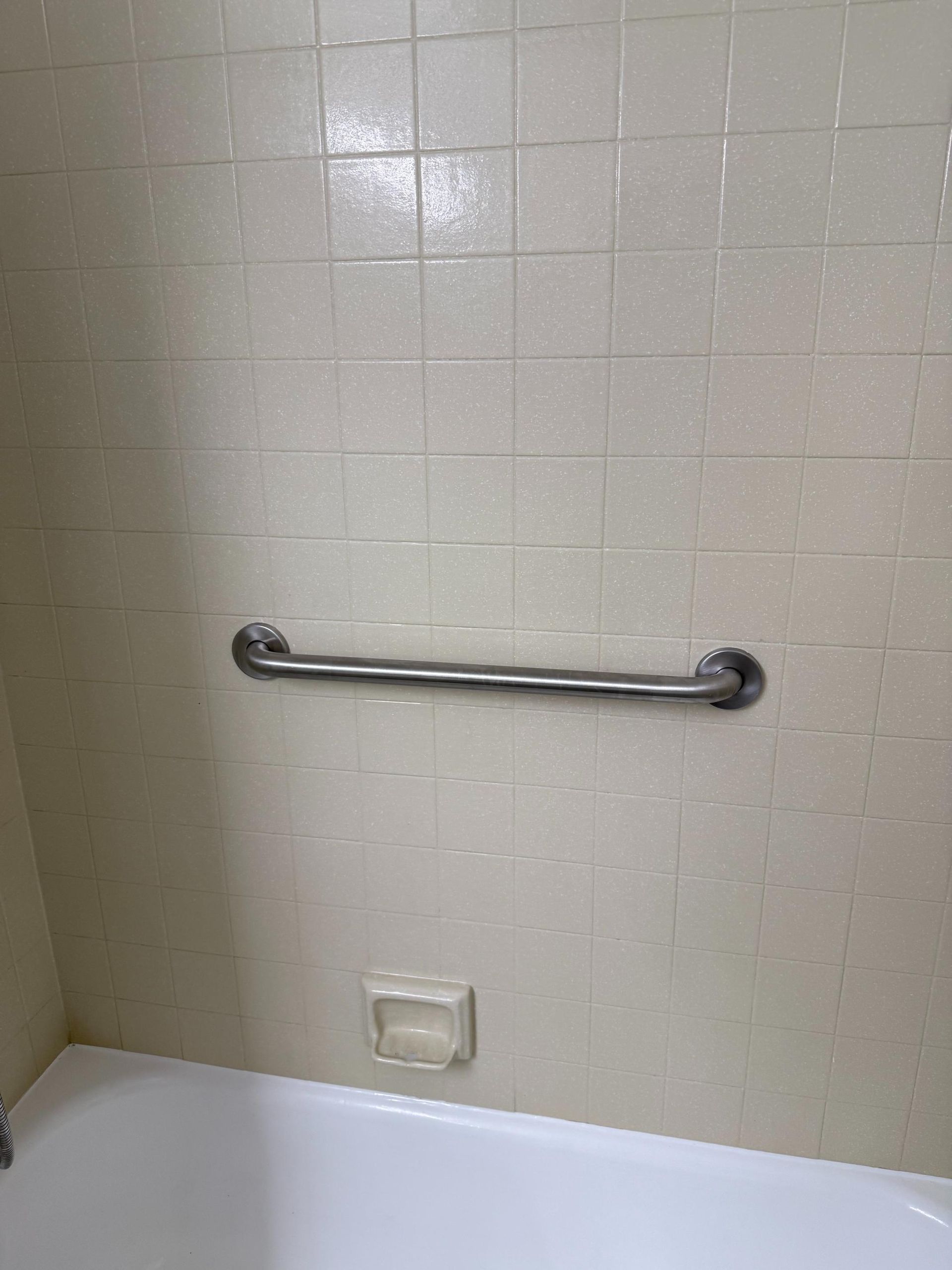 A bathroom with a bathtub and a towel bar on the wall.