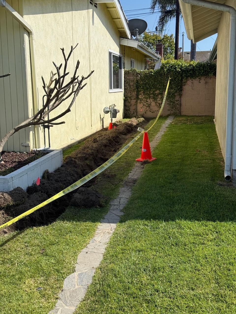 A backyard with a yellow tape and orange cones