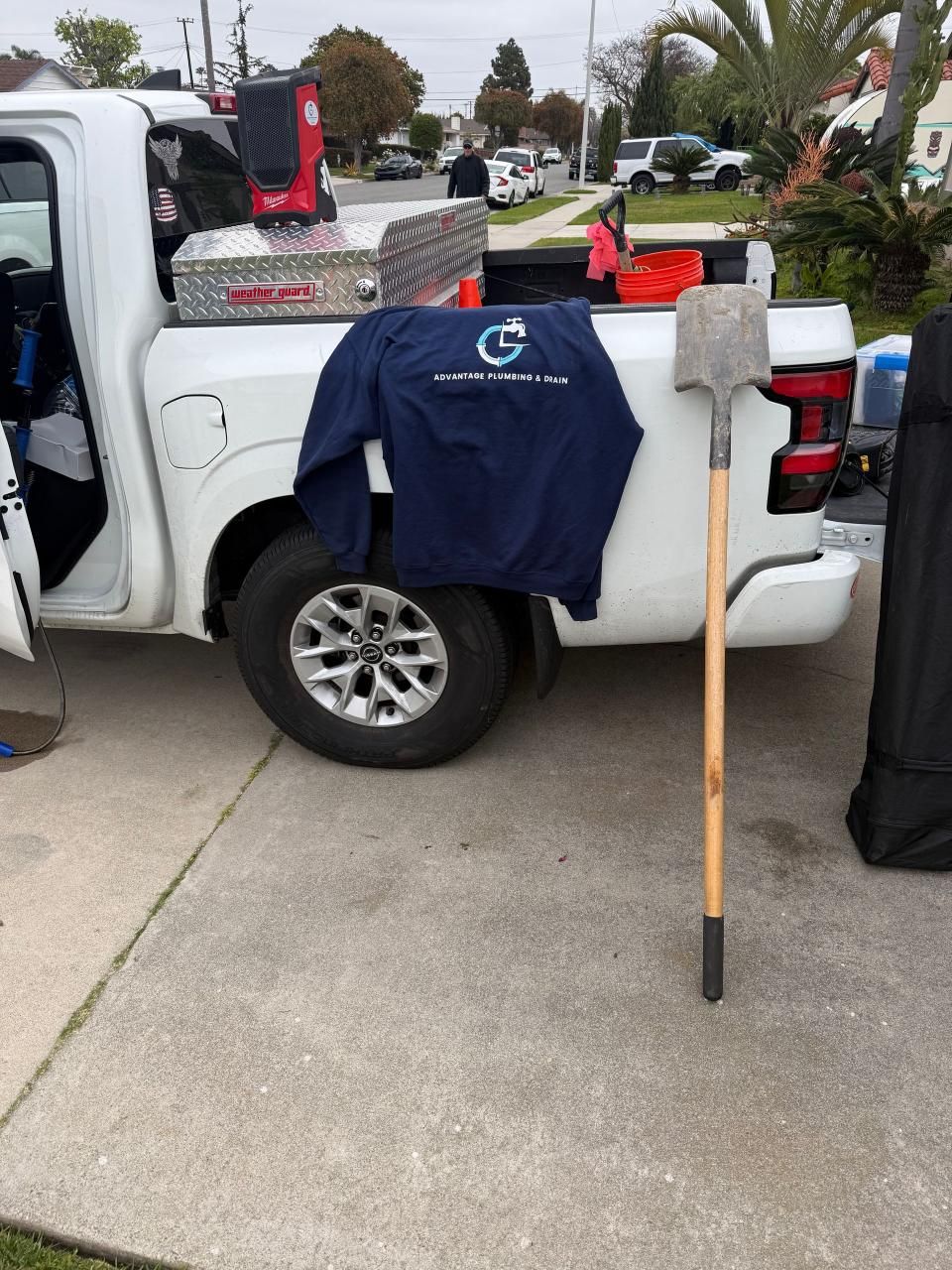 A white truck with a shovel in the back