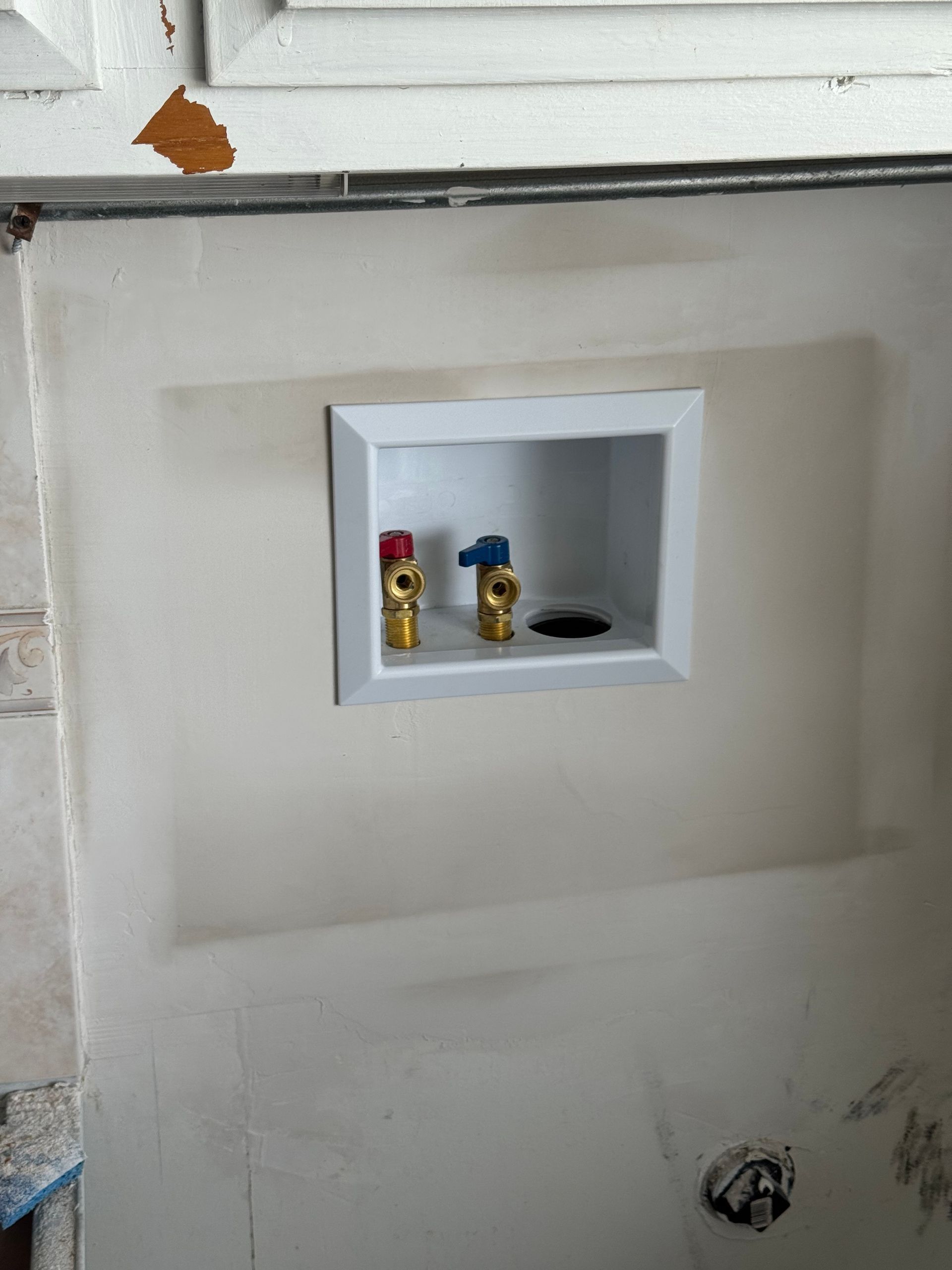 A hole in a wall with two valves in it