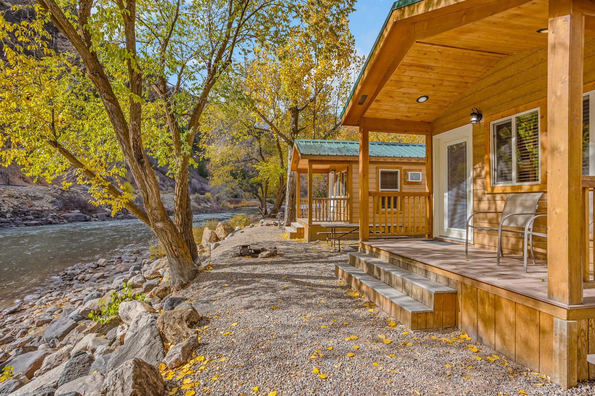 A wooden house with a porch next to a river.