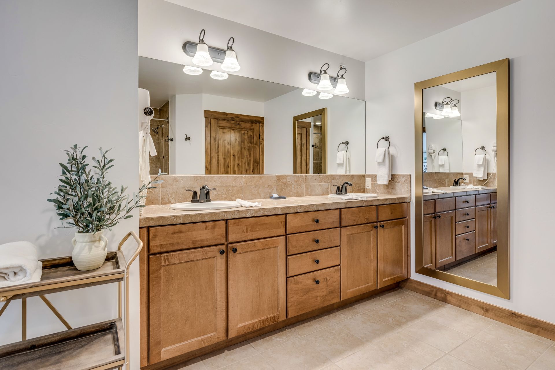 A bathroom with two sinks and a large mirror.