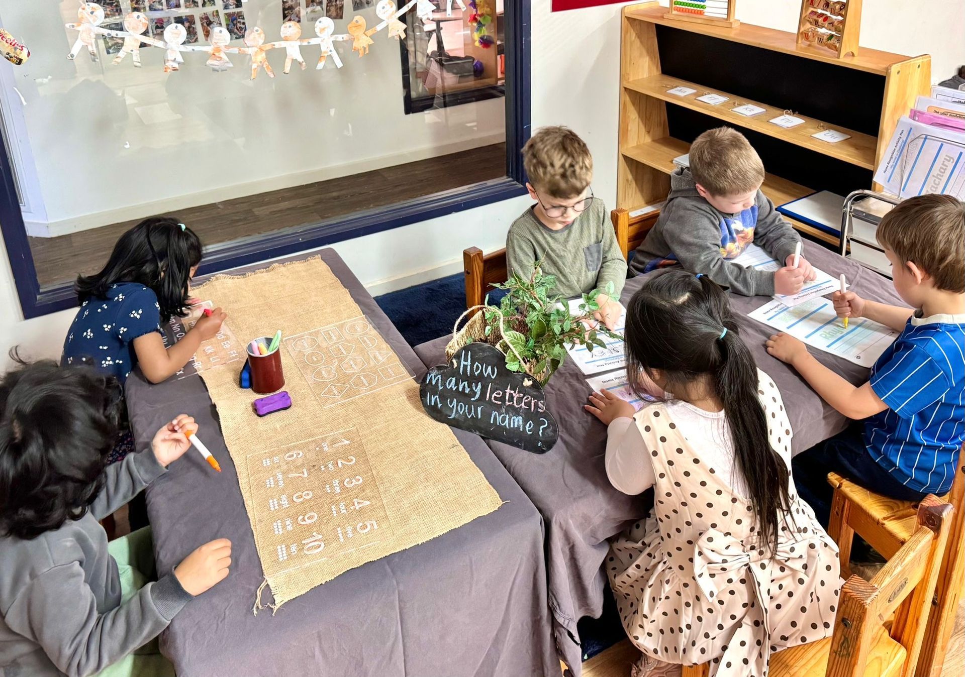 A father takes a photo of his two children, a boy and a girl, as they leave home for kindergarten.