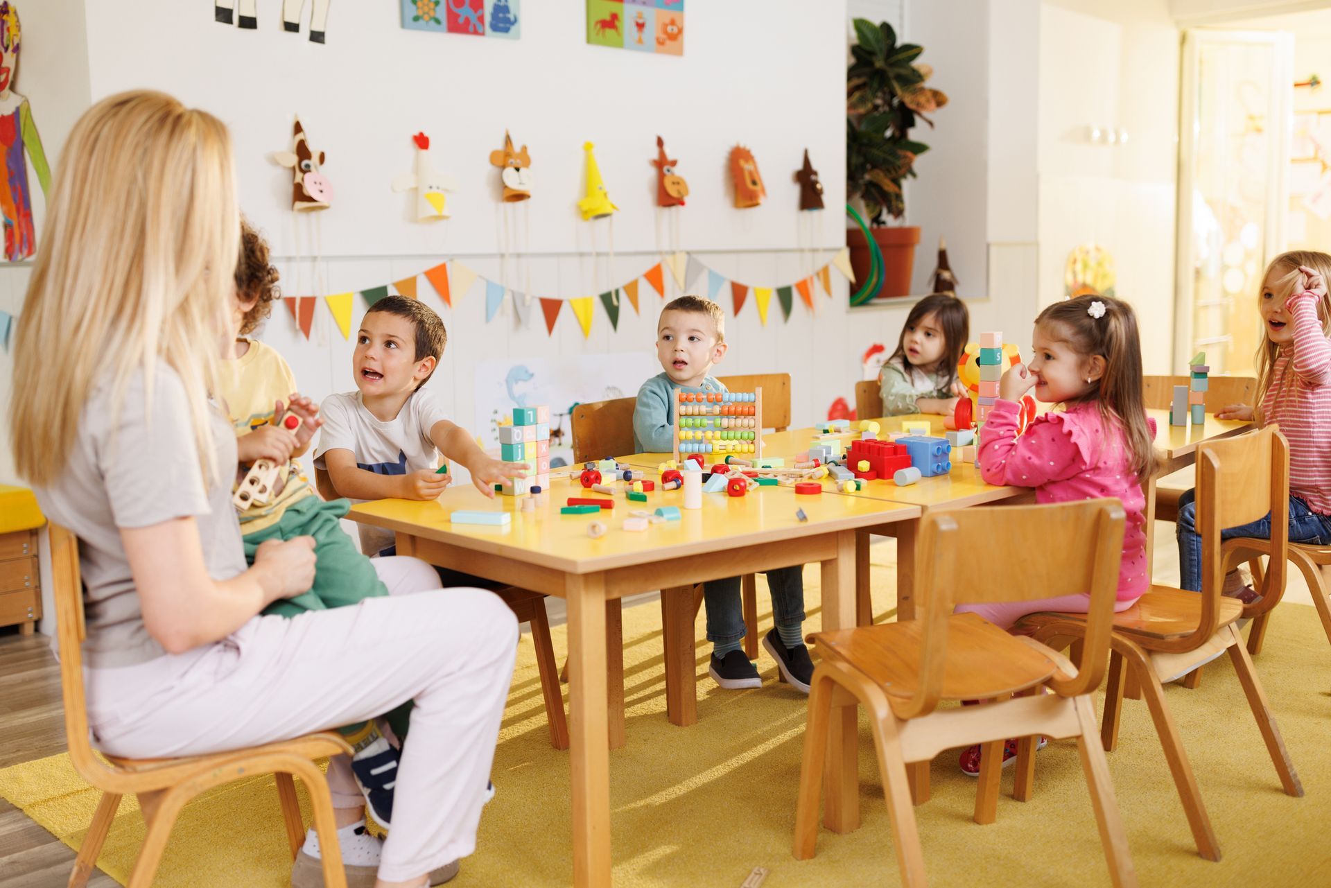 A group of children is sitting at a table and playing in the kindergarten. A group of children is sitting at a table and playing in the kindergarten.