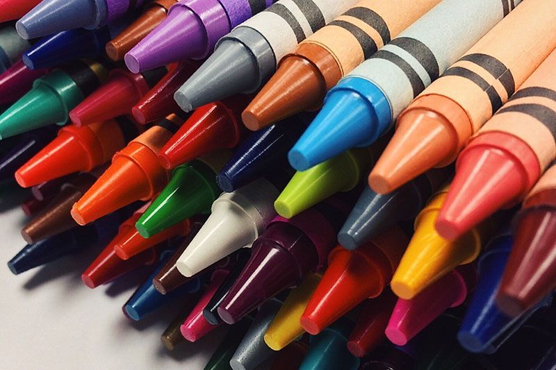 a bunch of crayons of different colors are lined up on a table
