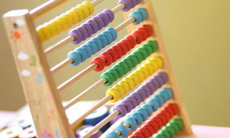 a wooden abacus with colourful beads is sitting on a table .