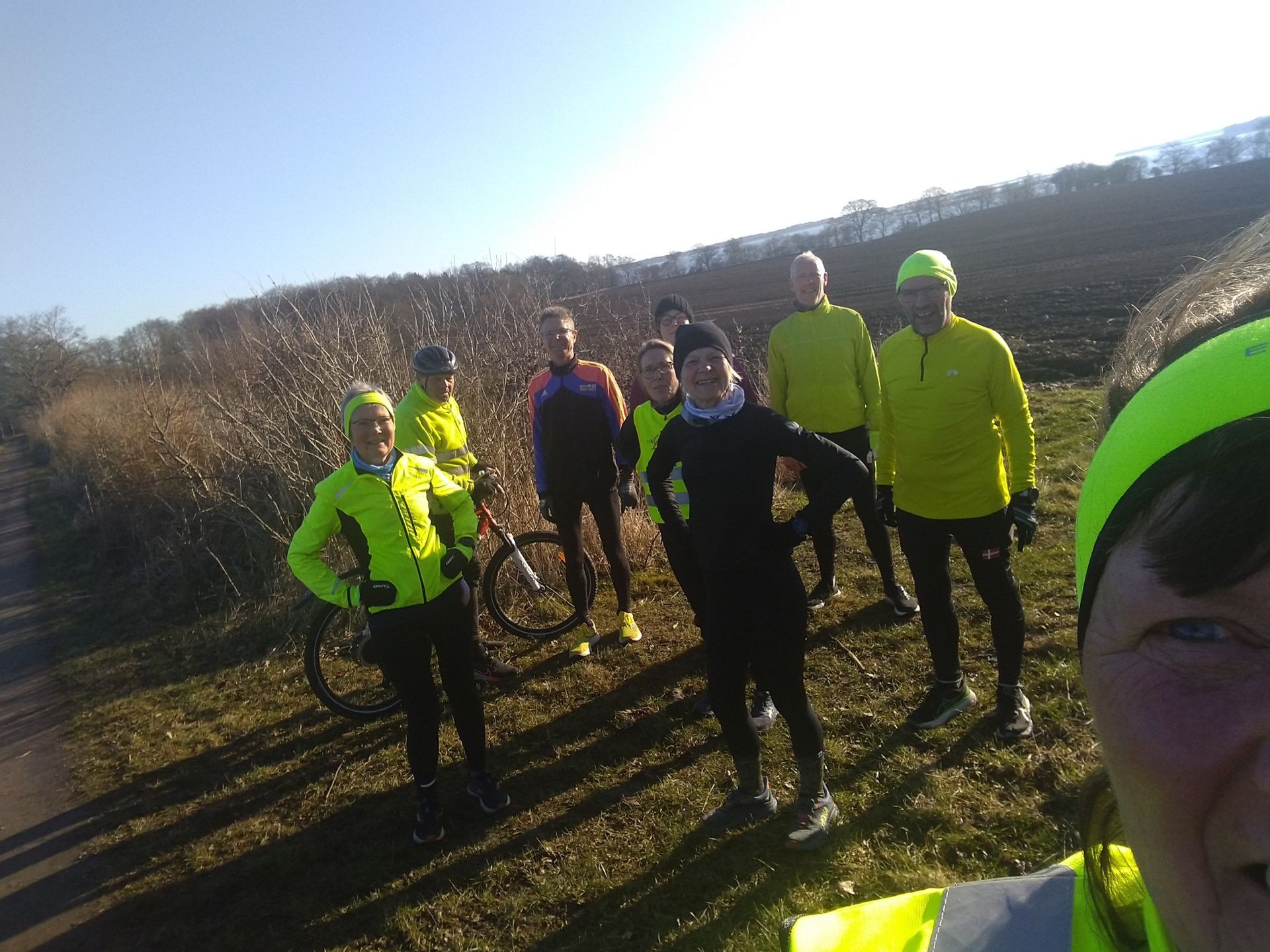 En gruppe mennesker står ved siden af ​​hinanden på en mark.