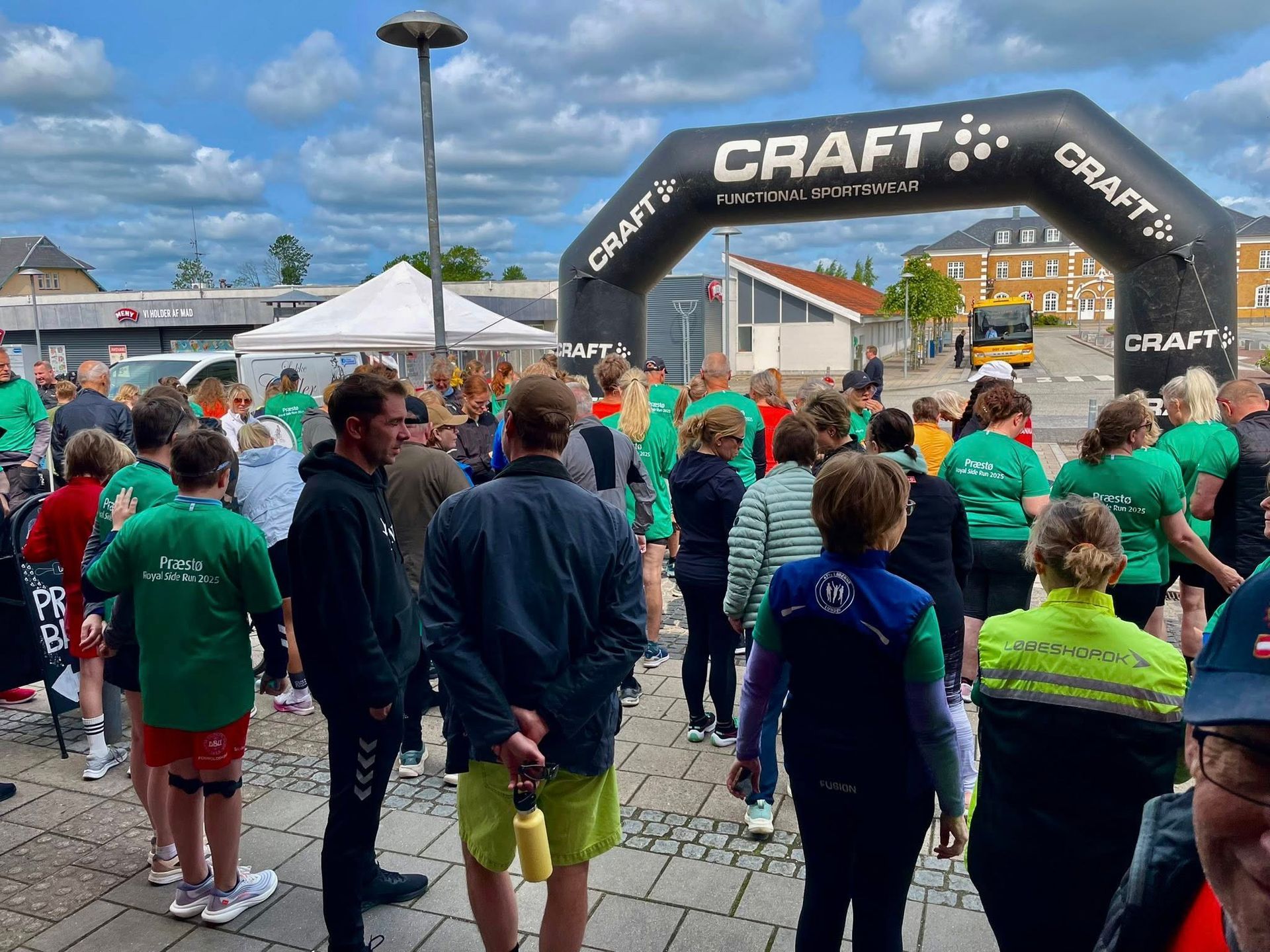 En stor gruppe mennesker står foran en oppustelig buegang til et håndværk.