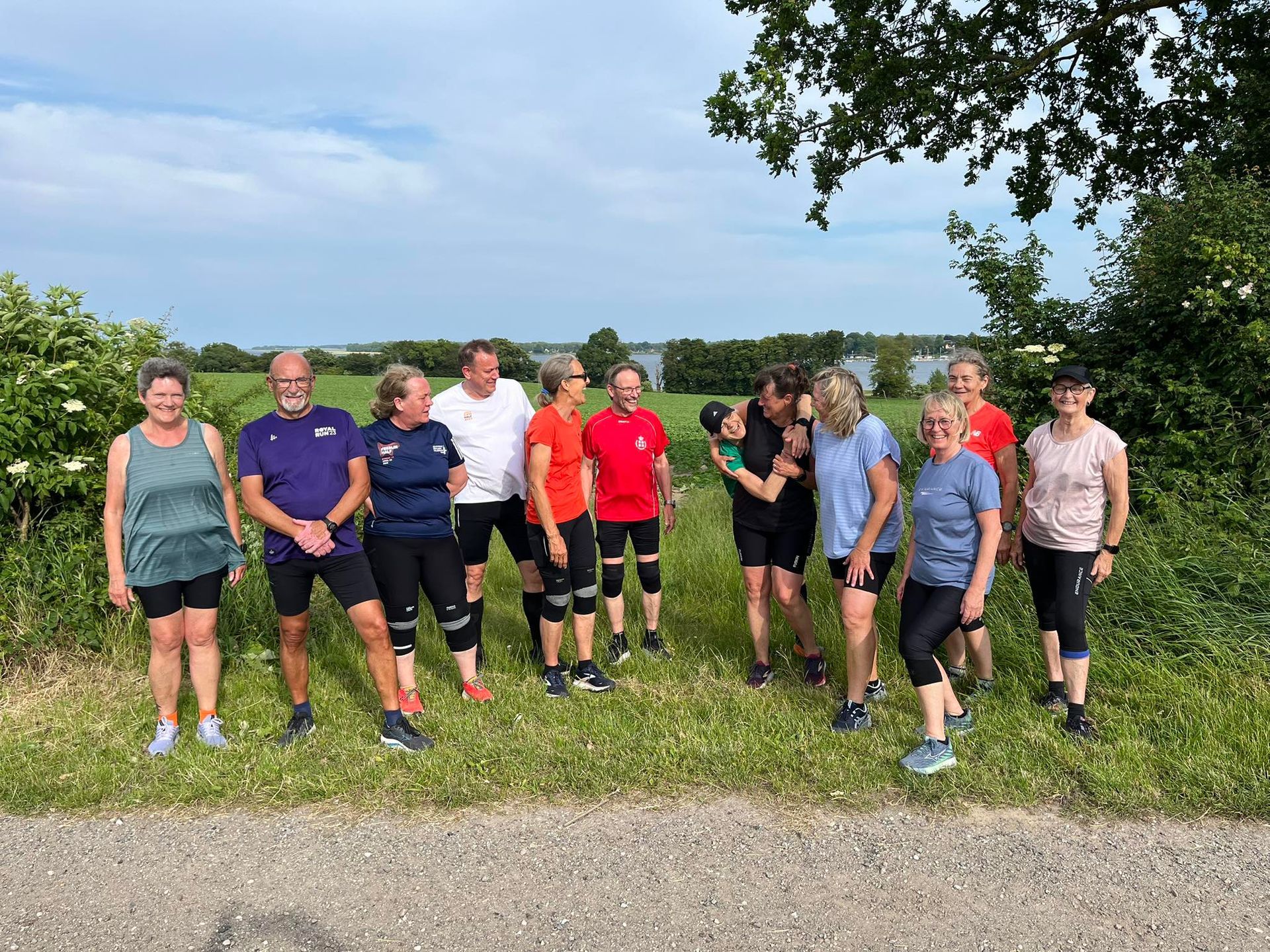 En gruppe mennesker står ved siden af ​​hinanden på en mark.