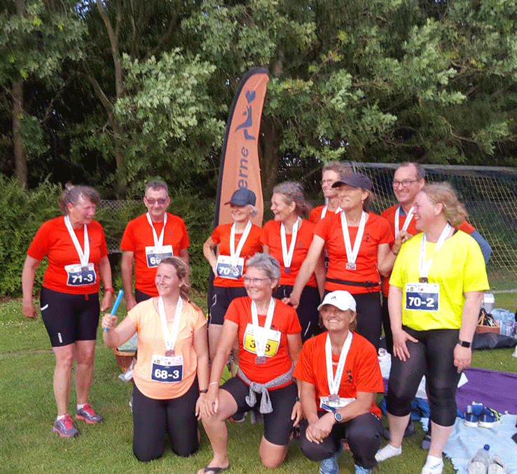 En gruppe mennesker poserer til et billede, hvor en af ​​dem bærer et mærke med teksten 70-2