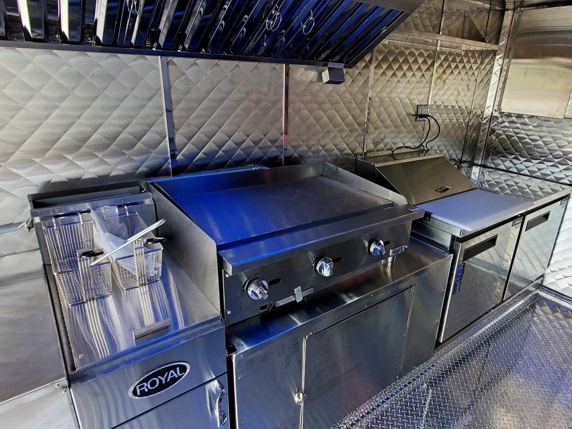 Stainless steel flat top grill inside a compact food truck kitchen