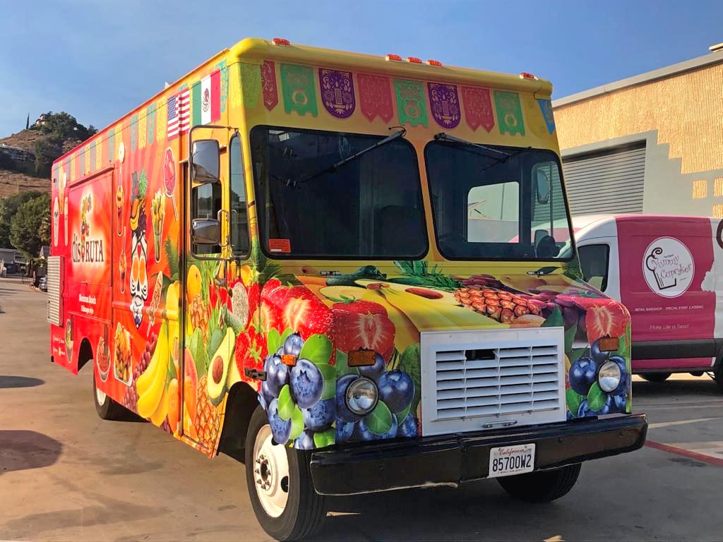 A colorful juice truck is parked in SD Food Truck Pros parking lot.