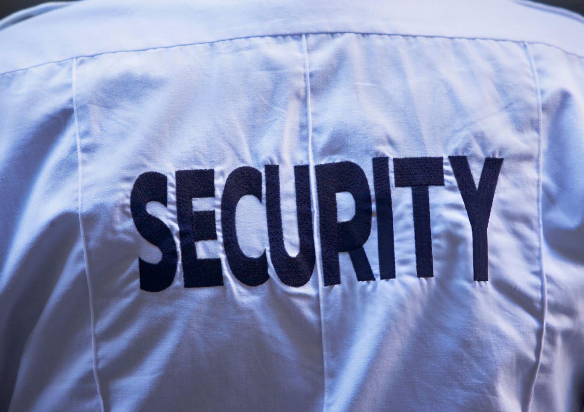 Back of a security guard's uniform with the word 