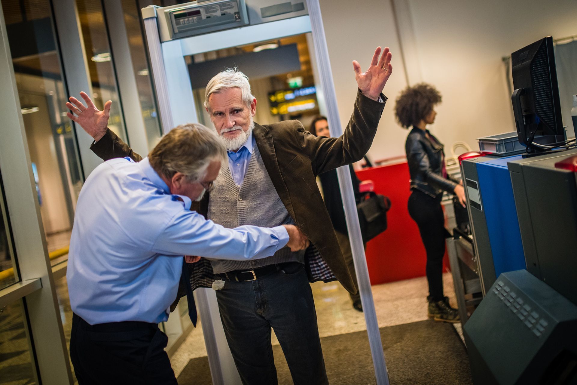 A man is getting through a metal detector at an airport.