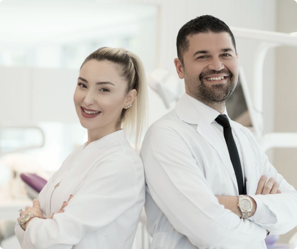 A man and a woman are standing back to back in a dental office.
