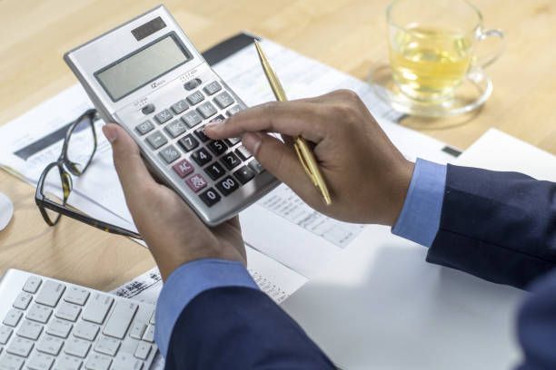 Tax accountant using a calculator to analyze data and support accurate tax planning for businesses.