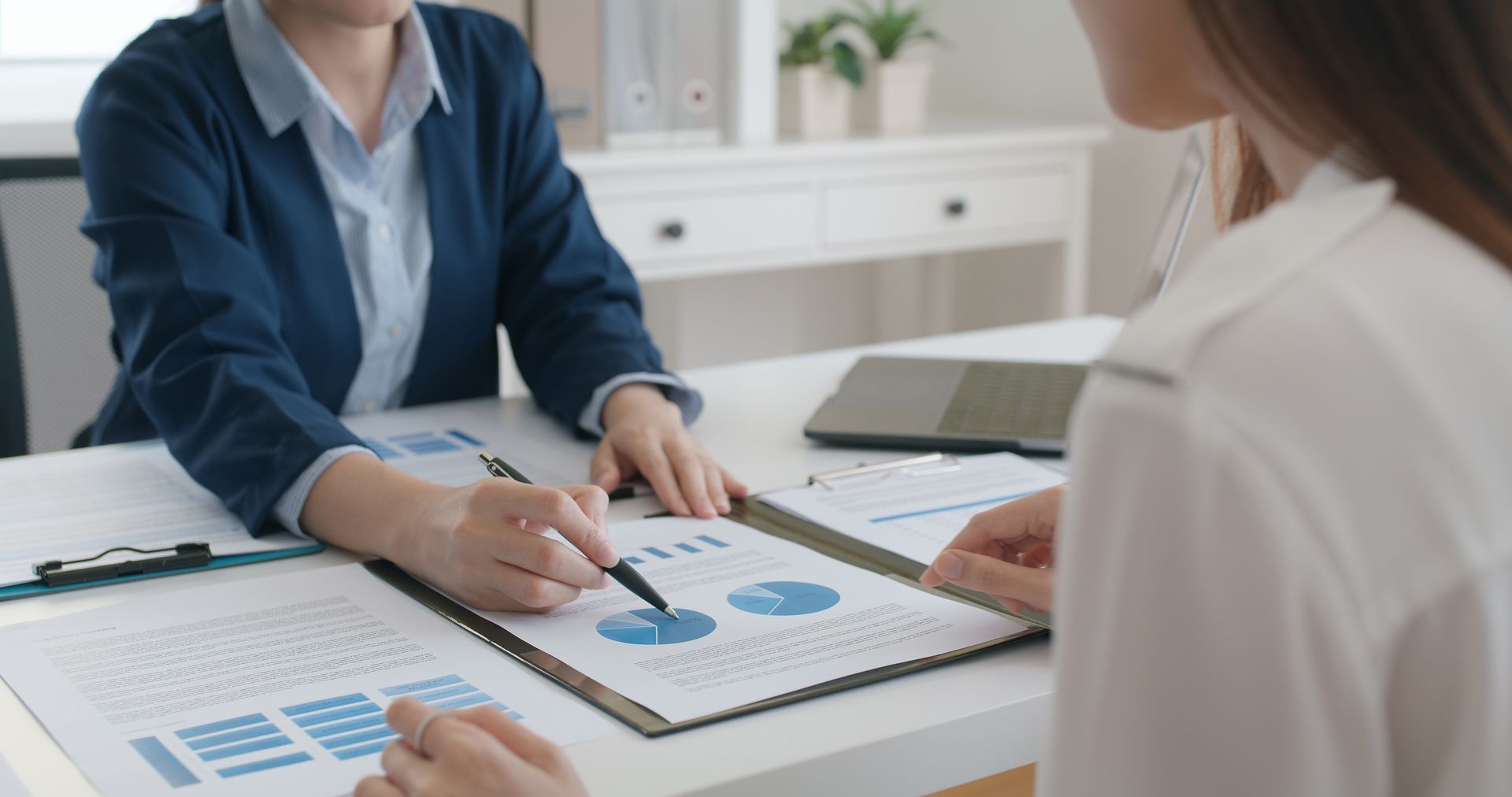 Two people reviewing charts at a desk