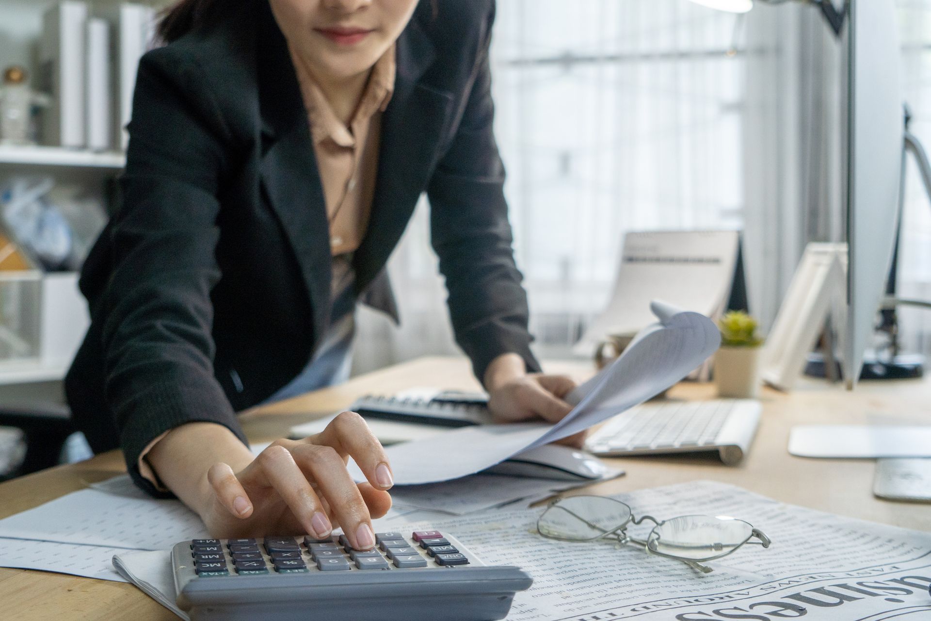 Finance staff calculating with a paper on the hand.