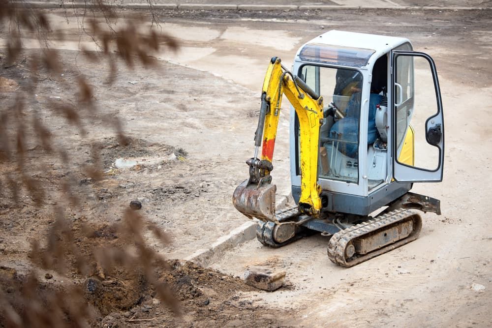 A Small Excavator Is Digging A Hole In The Ground - Micro Excavations & Earthmoving in Southport, QLD