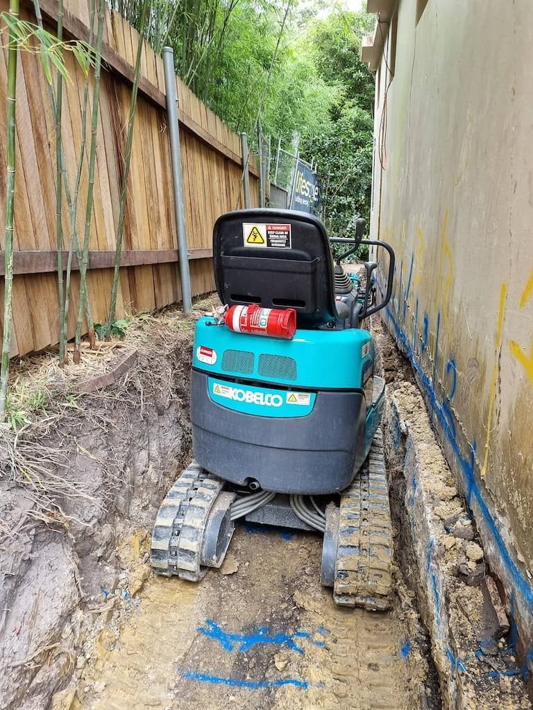 A Kobelco Mini Excavator Is Sitting In The Dirt - Mini Earth Works & Excavation on the Gold Coast, QLD