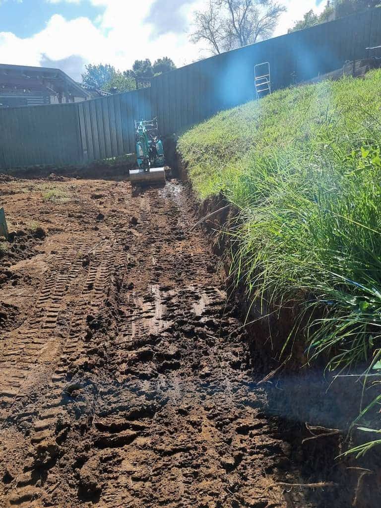 A Muddy Dirt Road With A Fence In The Background - Reliable Micro Excavator on the Gold Coast, QLD
