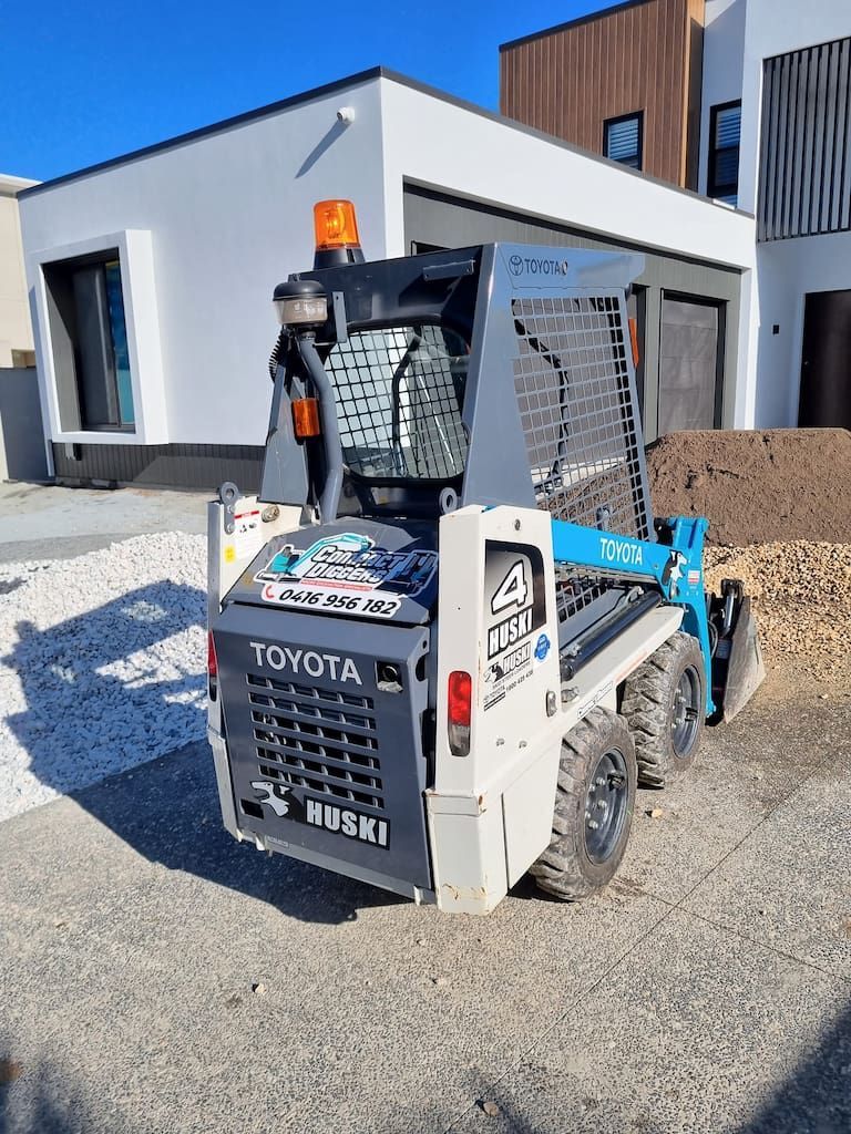 A Skid Steer Is Parked In Front Of A House - Book a Micro Bobcat on the Gold Coast, QLD