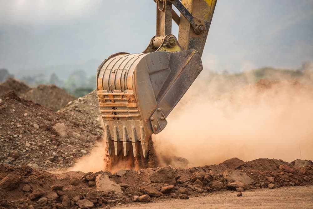 A Bulldozer Is Digging A Hole In The Dirt At A Construction Site - Micro Excavations & Earthmoving in Southport, QLD