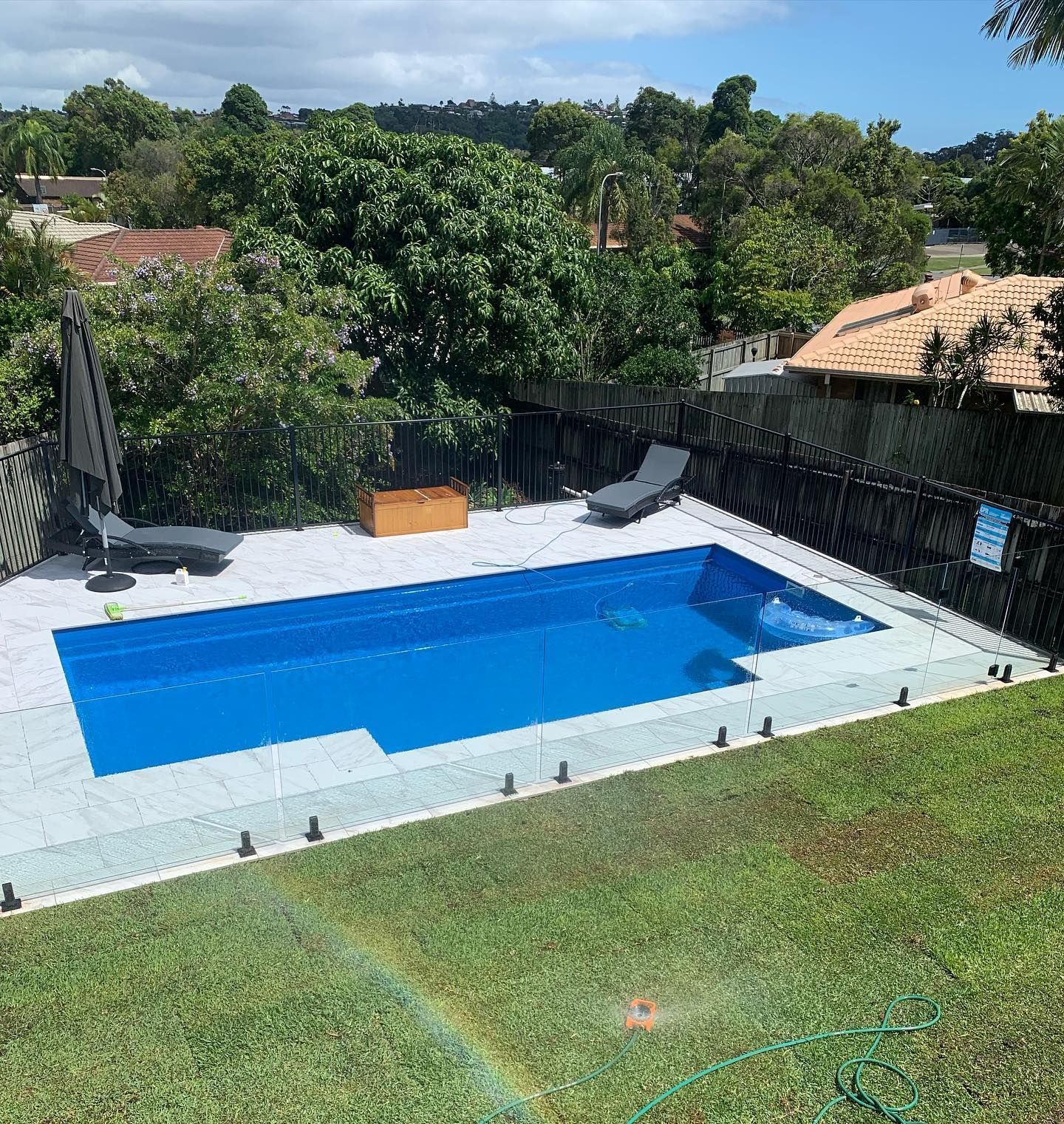 Backyard Pool With Blue Water and Surrounding White Tiles — Bombs Away Pools in Coolangatta, QLD
