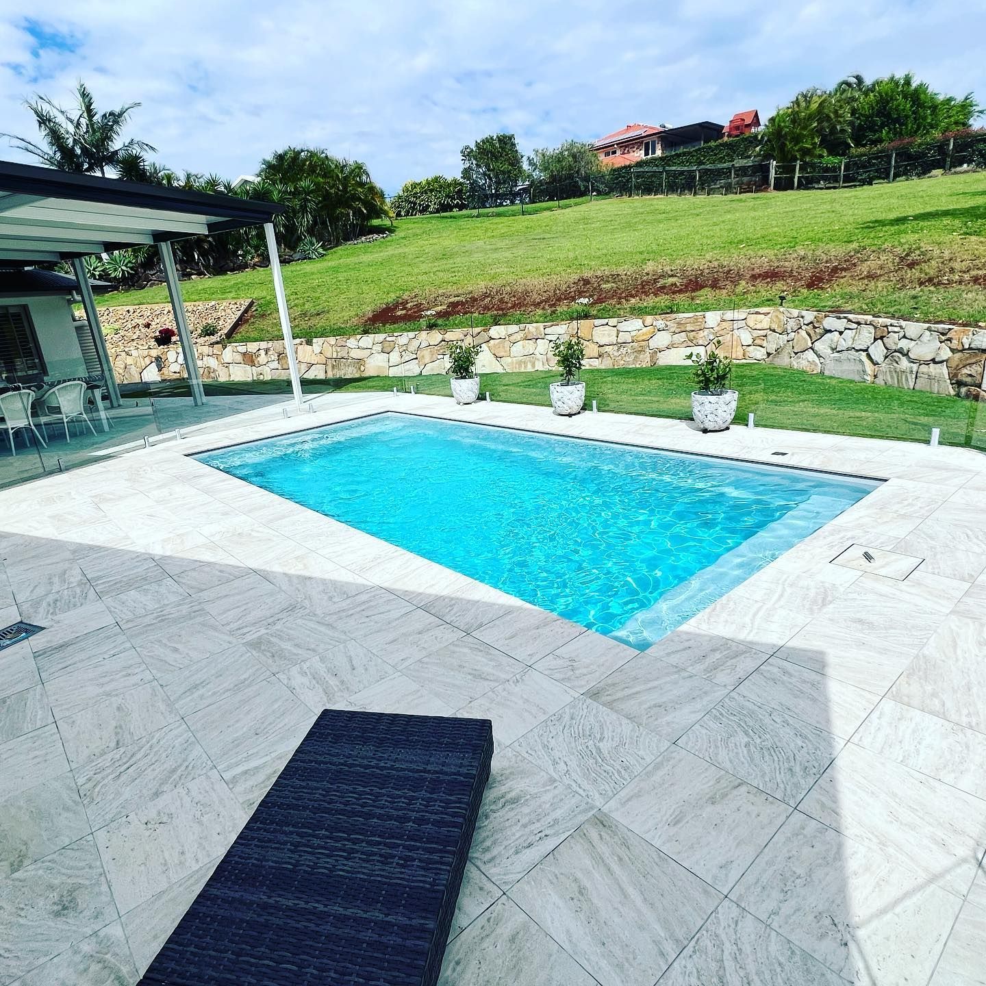 Swimming Pool With Blue Water Surrounded by Stone Tiles — Bombs Away Pools in Coolangatta, QLD