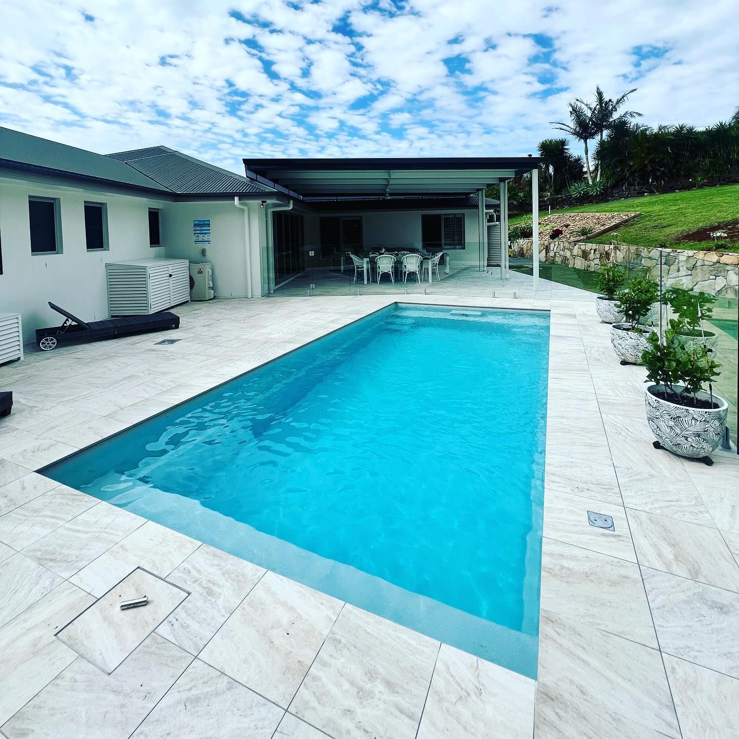 A Rectangular Swimming Pool Surrounded by a Patio, Home, and Greenery — Bombs Away Pools in Coolangatta, QLD