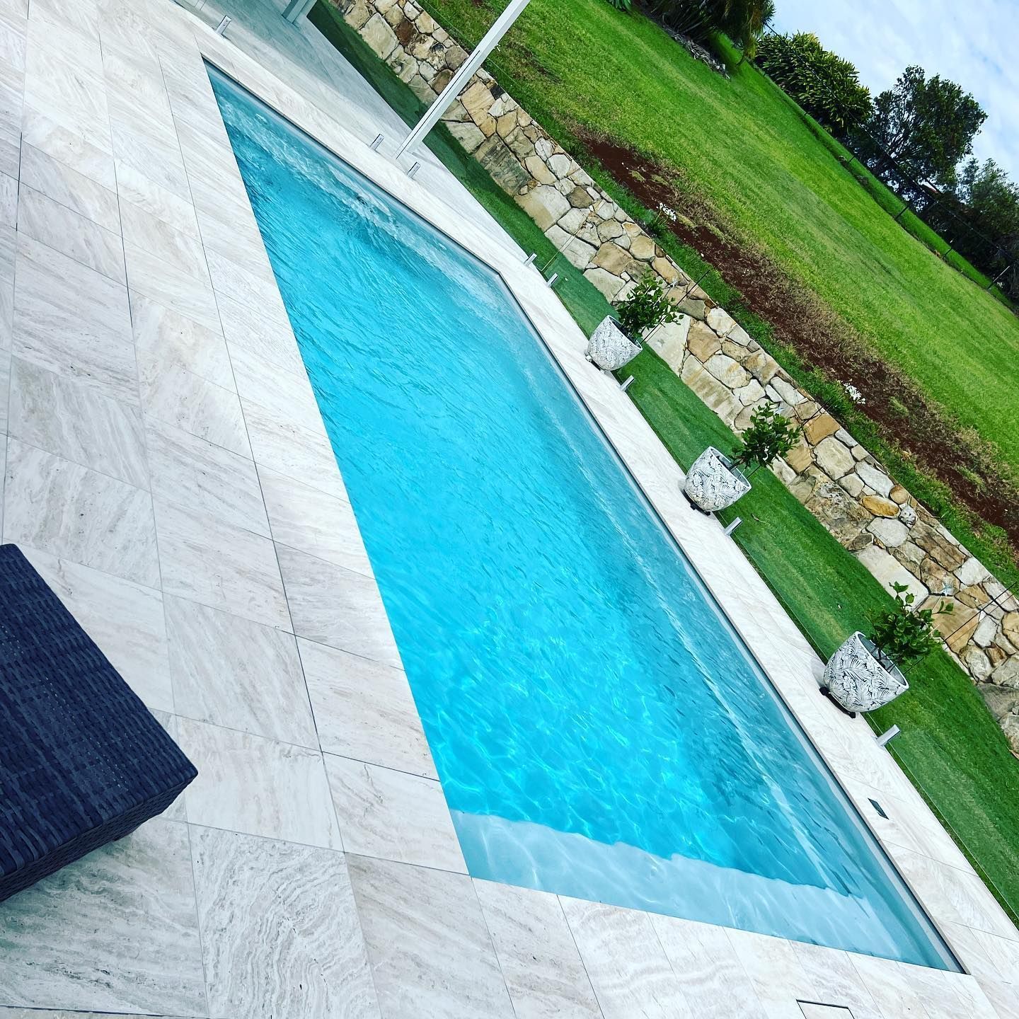Rectangular Swimming Pool With Blue Water Next to a Stone Patio — Bombs Away Pools in Coolangatta, QLD