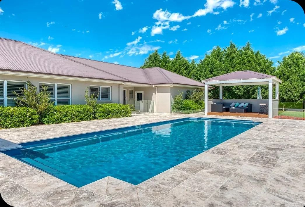 Poolside View of a House With a Pool, Gazebo, and Blue Sky — Bombs Away Pools in Coolangatta, QLD
