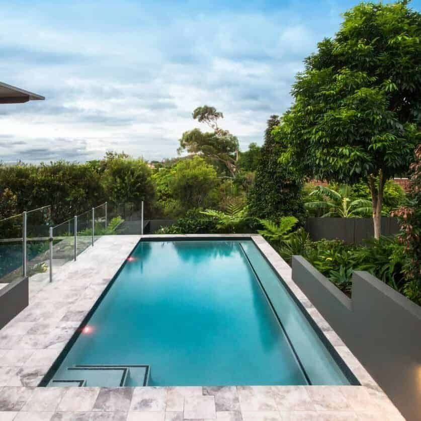 Rectangular Swimming Pool Surrounded by Gray Stone, Lush Greenery — Bombs Away Pools in Coolangatta, QLD