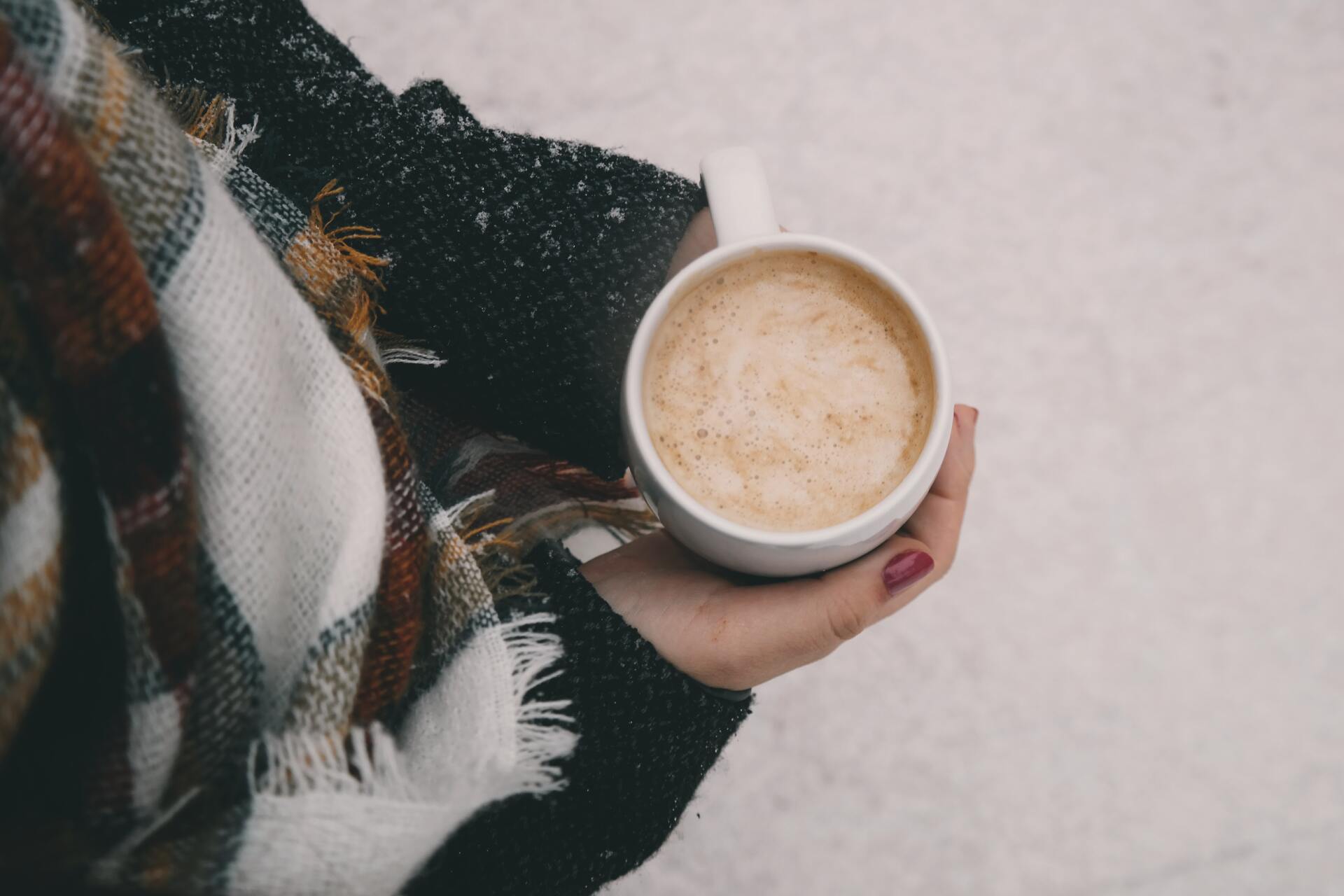Someone drinking a hot drink to stay warm