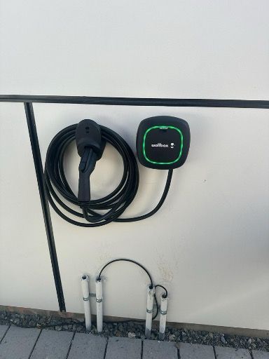 A charging station for electric cars is attached to a wall.