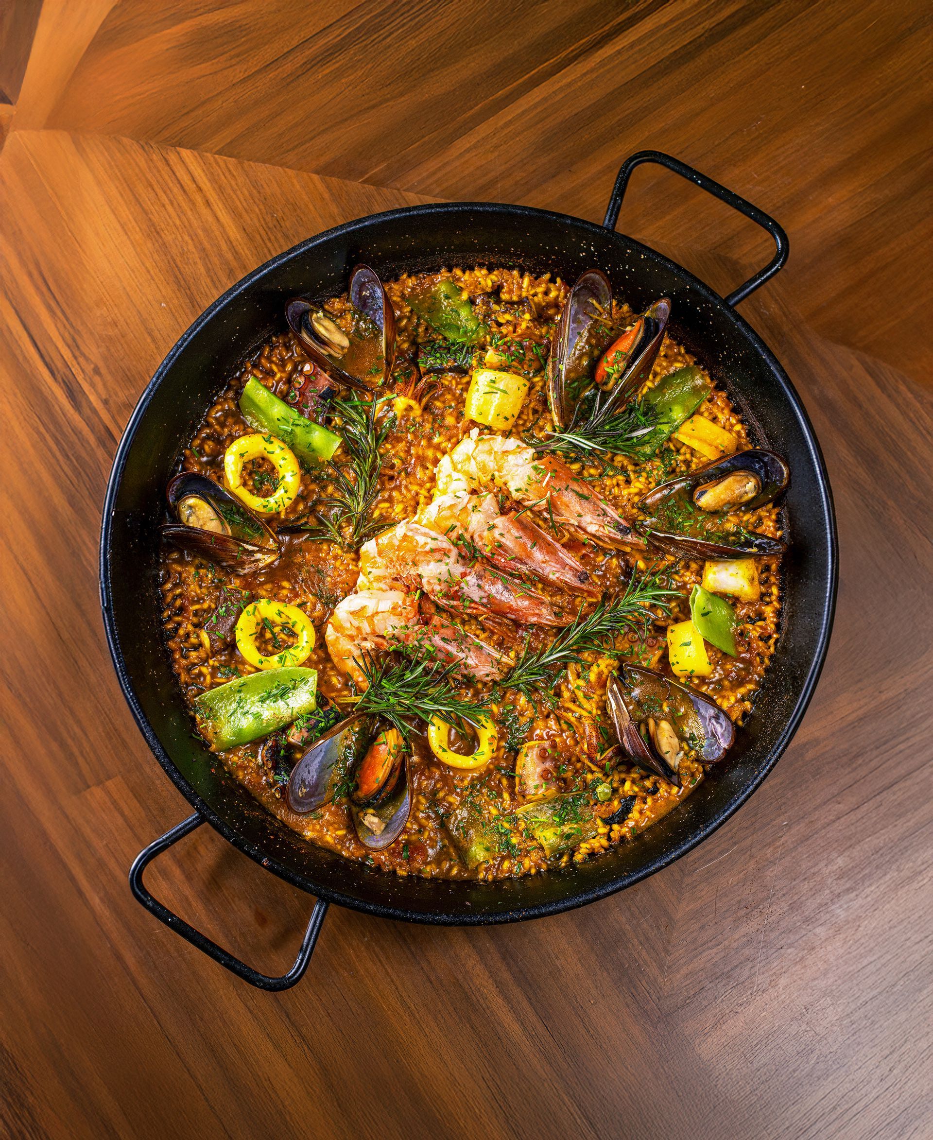 Um quarto de hotel moderno com uma cama bem arrumada, uma televisão fixada na parede, uma pequena escrivaninha e acesso ao banheiro.