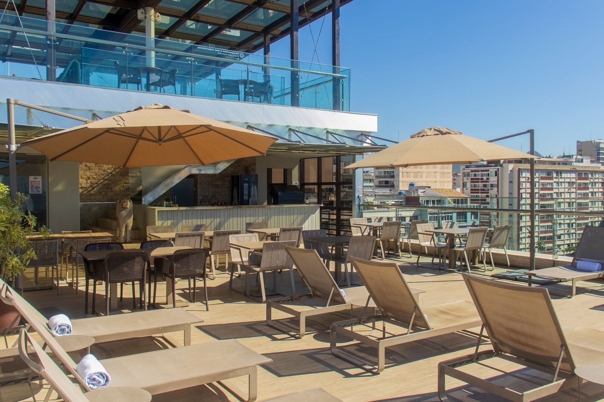 Um quarto de hotel moderno com uma cama bem arrumada, uma televisão fixada na parede, uma pequena escrivaninha e acesso ao banheiro.