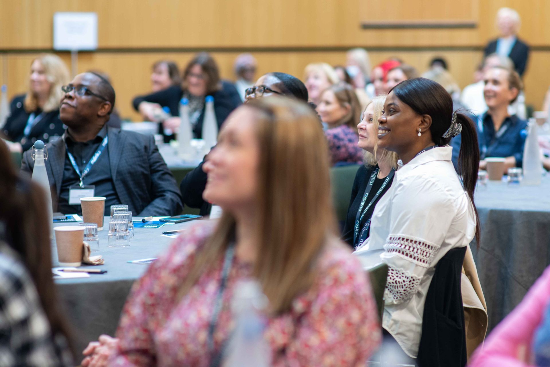 A group of people are sitting at tables at a conference.