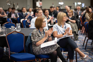 A group of people are sitting in chairs at a conference.