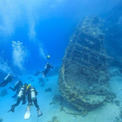 Los buzos exploran un barco hundido en las claras aguas del océano azul.