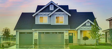 A large white house with a blue roof and a green garage door.