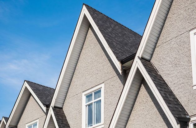 A row of houses with a blue sky in the background.