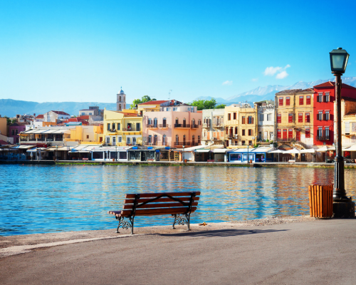 A bench sits on the shore of a body of water in front of a Chana - Blog Post Barters Travelnet