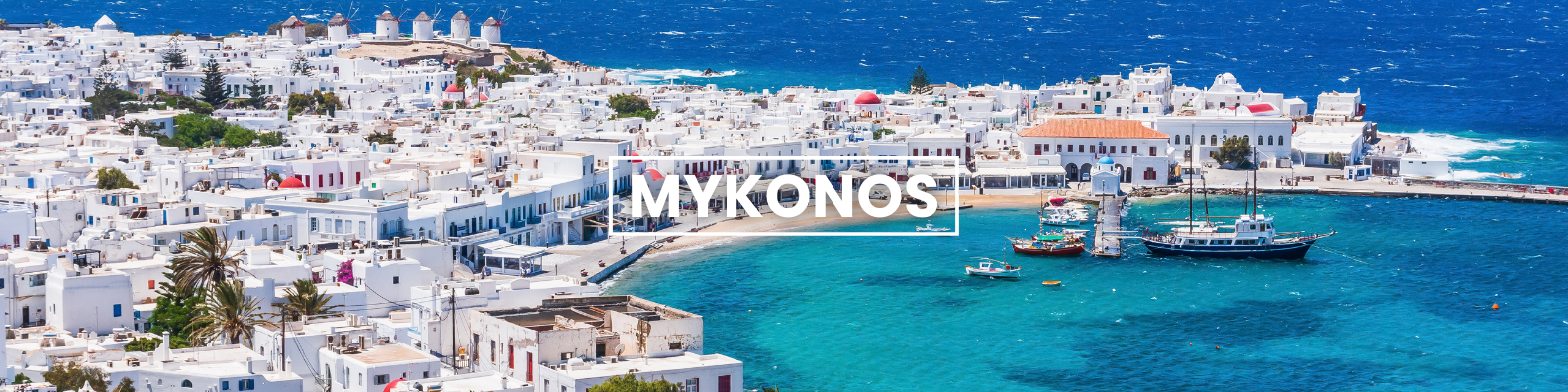 an aerial view of the city of mykonos with boats in the water .