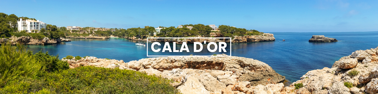 a large body of water surrounded by rocks and trees . in cala d'or Barter'sTravelnet