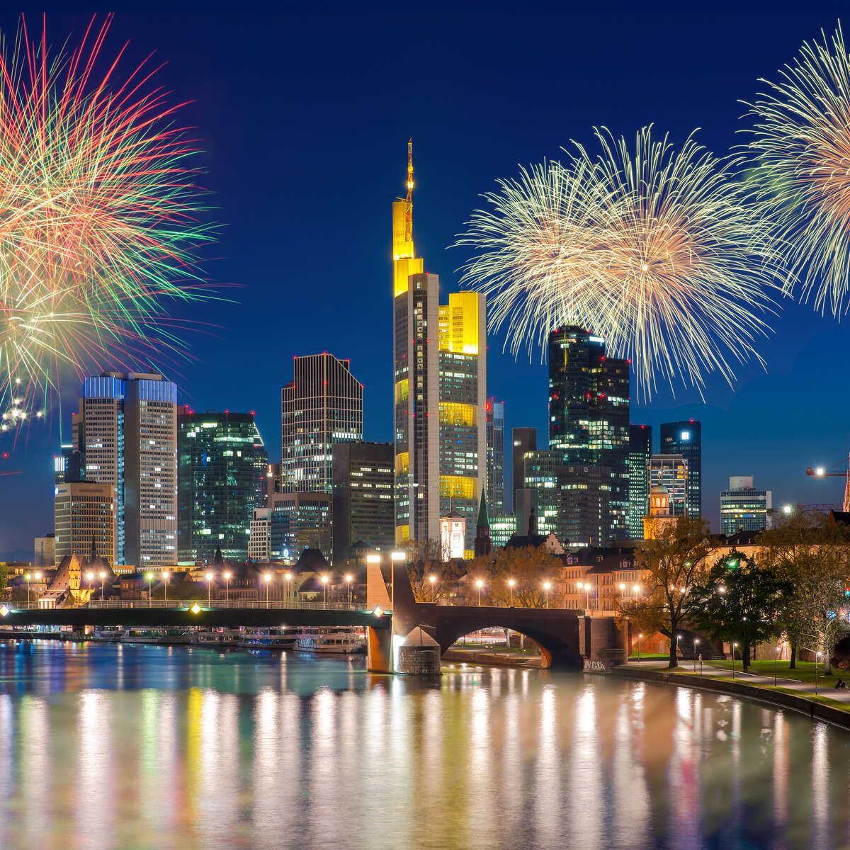 Fireworks are displayed over a city skyline at night