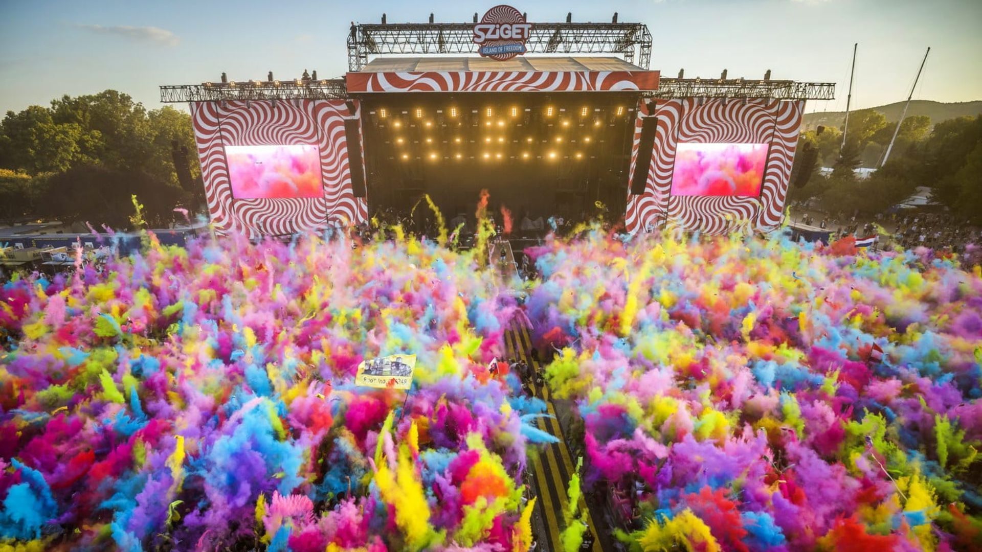 Sziget Music Festival in Hungary crowd throwing rainbow colours power into the air