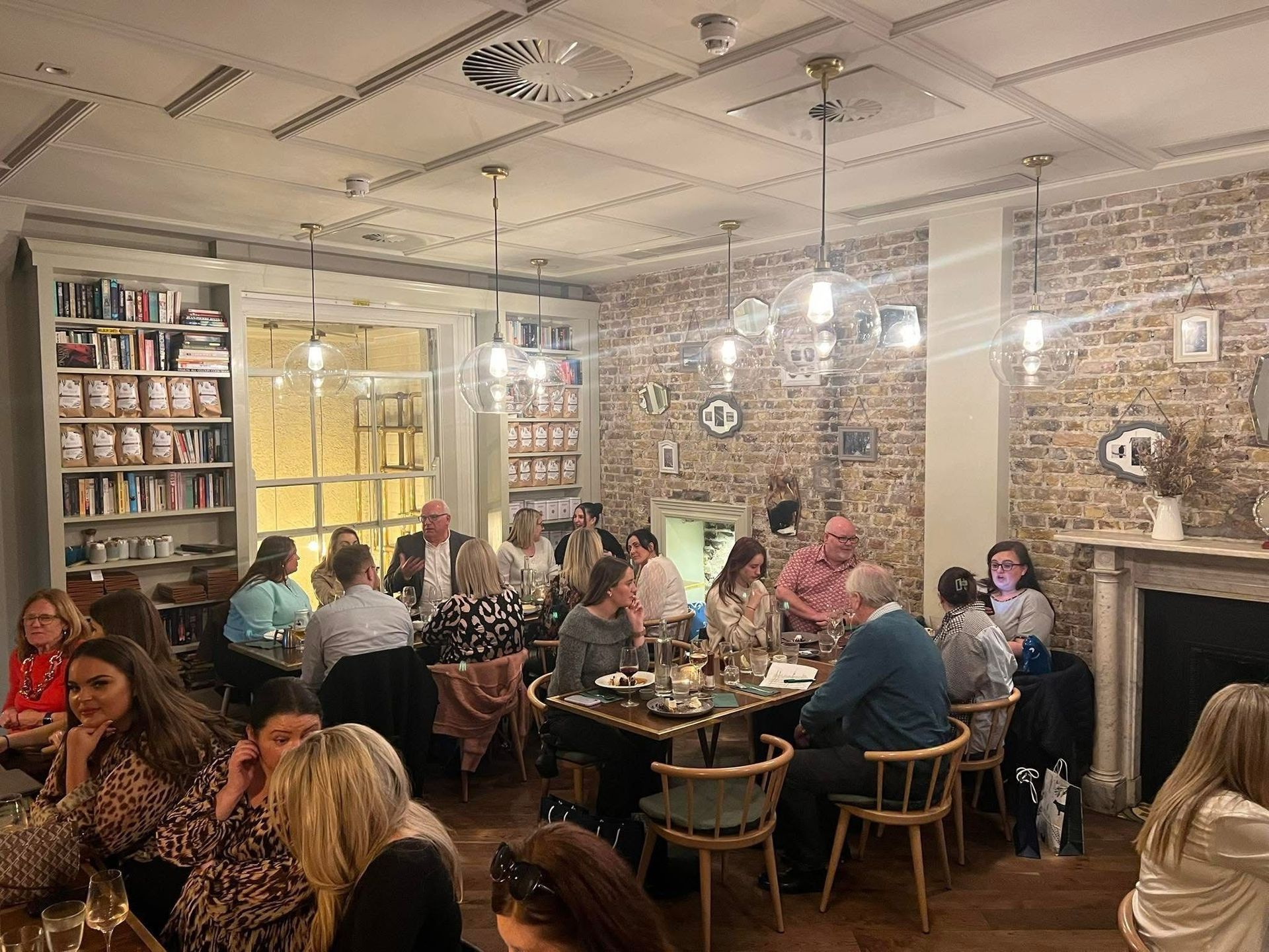 A group of people are sitting at tables in a restaurant.